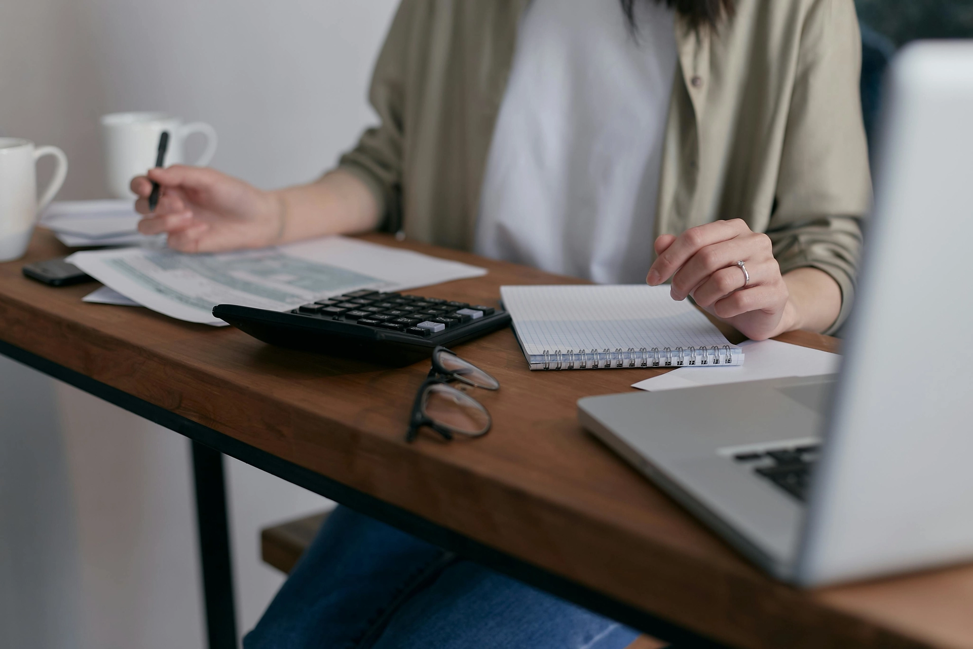 Woman doing finances at a wooden desk